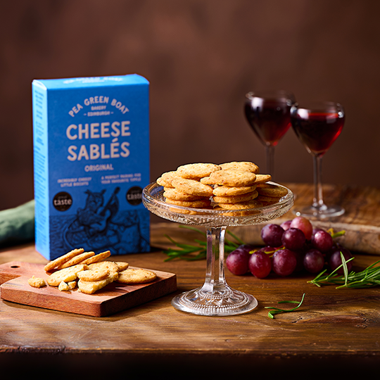 Cheese Sables on a platter with a glass of red wine at the side